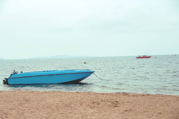 Two fishing boats on the beach with the sea on the horizon