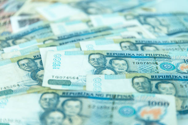 Kazakh coins in denominations of 20, 50, 100 and 200 tenge stand on a table on a black background with vertical copy space.