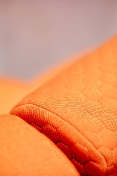 istock Macro Shot: Quilted Orange Textile with Delicate Seams and Textured Surface Great for Background or Design Element 2205313440