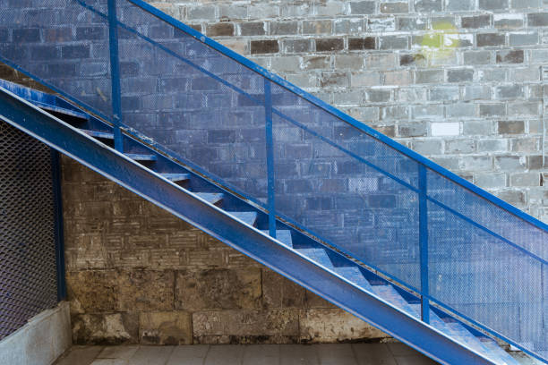 Blue iron stairs, gray brick wall