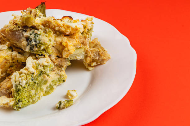This hearty casserole features layers of tender chicken fillet, fresh broccoli, and creamy egg mixture, all seasoned with garlic and topped with sour cream, perfect for a comforting meal.