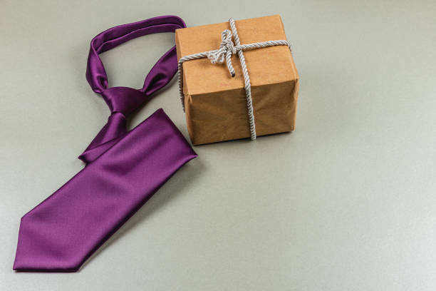 istock Fathers Day gift ideas featuring a purple tie and wrapped present for dad 2205322094