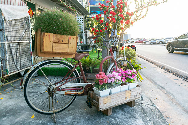 Vintage bicycle adorned with vibrant flowers in wooden boxes creates a charming urban scene. This unique display offers a blend of nature and creativity in an outdoor setting.