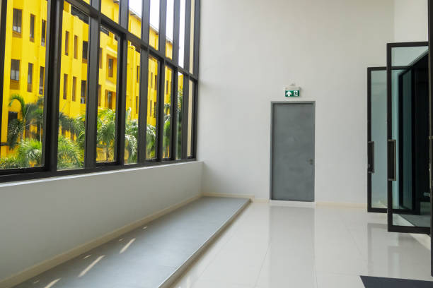 This image showcases a bright and modern interior with large windows revealing a vibrant yellow building. The minimalist design exudes tranquility and inviting ambiance.