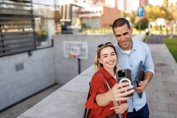 istock Two colleagues on coffee break taking selfie in front of business building 2205340384
