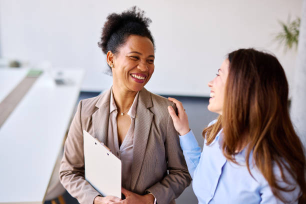 istock Two smiling businesswomen talking and having fun in the office 2205342037