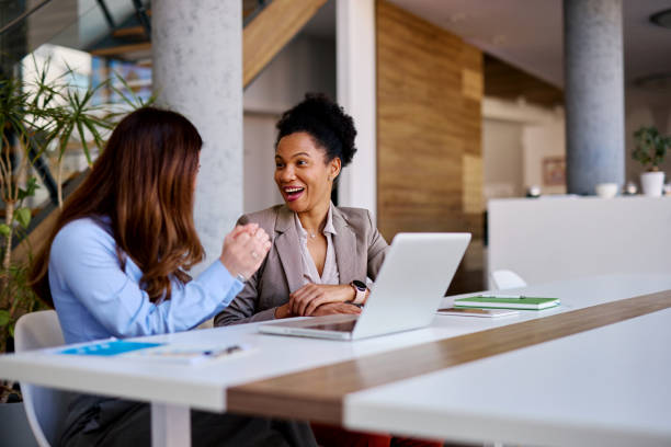 istock Businesswomen discussing strategy in modern office using laptop 2205342215