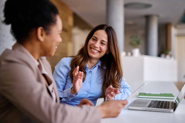 istock Two businesswomen discussing happily in the office 2205342232