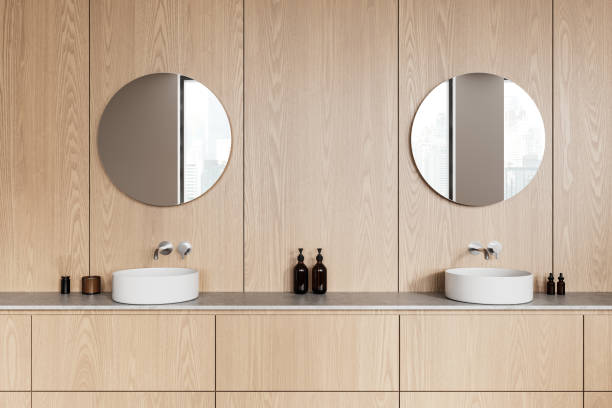 istock Modern bathroom interior with wooden cabinets, round mirrors, and white vessel sinks. 3D Rendering 2205342467