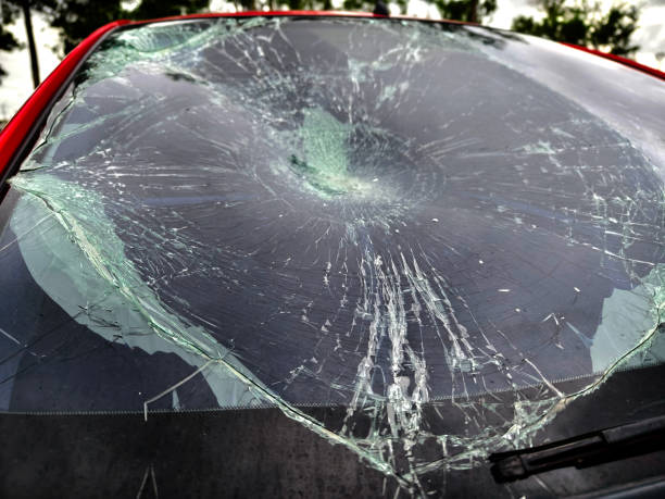 istock Shattered and broken windshield on a bright red car showcasing the damage to its glass surface 2205345732