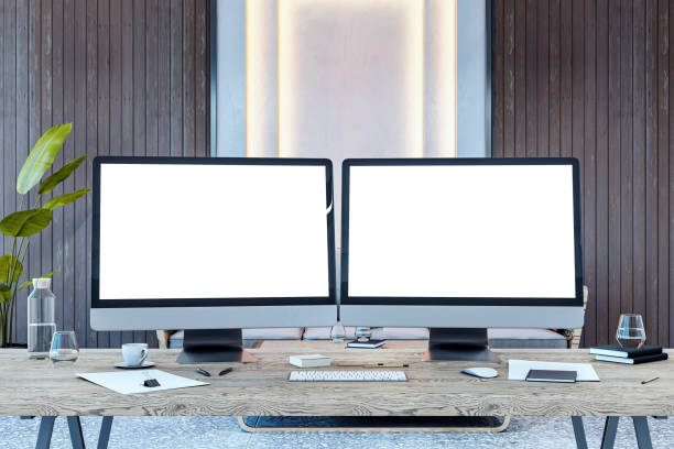 istock Dual desktop computer screens with blank mockups on a wooden desk in a modern office interior. 3D Rendering 2205348775