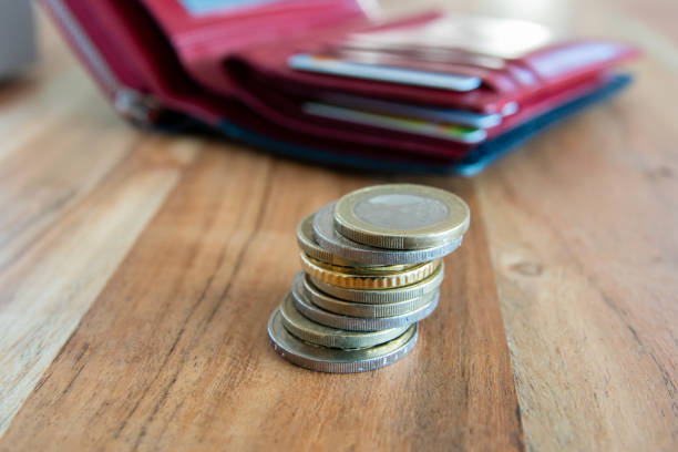 Coins stack on the wood table near the leather partmone. Wallet with european money for commerce business concept.