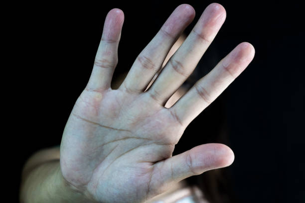 istock A person's hand is raised in a 'stop' gesture against a dark background, symbolizing resistance, refusal, or setting boundaries. 2205356259