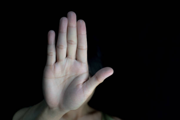 istock A raised hand against a black backdrop, signifying 'STOP' in a clear gesture, potentially representing rejection or a boundary being set. 2205356263