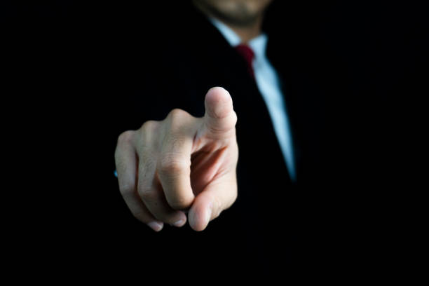 istock Businessman in suit pointing his finger forward. Suggests making a selection, directing, or indicating a choice. 2205356409
