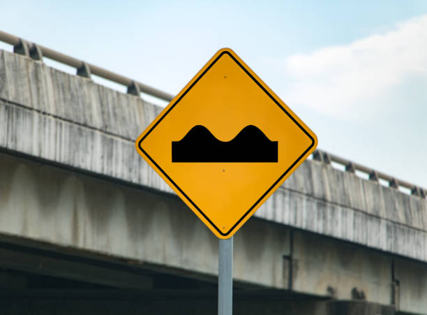 Road sign informs about bulges on road. Warning for damaged way.