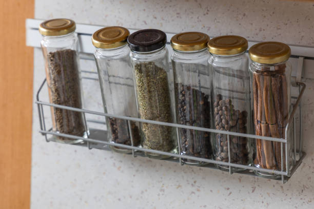 Spices in jars stored on a shelf in the kitchen