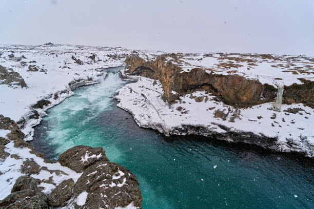 Turquoise detifoss river flowing through a canyon covered in snow during winter