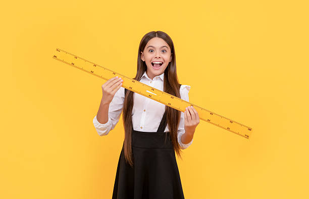 istock amazed kid in school uniform hold mathematics ruler for measuring, school 2205368045