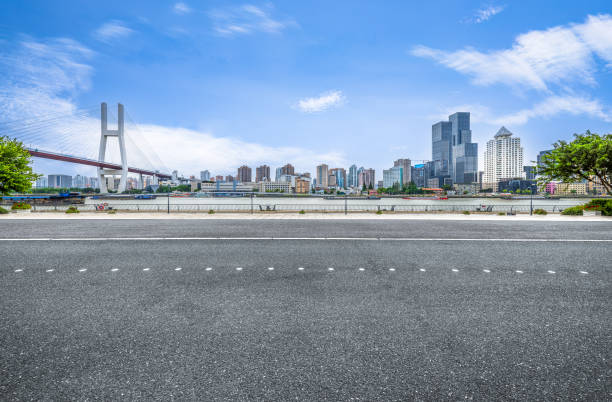 Empty asphalt road with modern city skyline and bridge in Shanghai