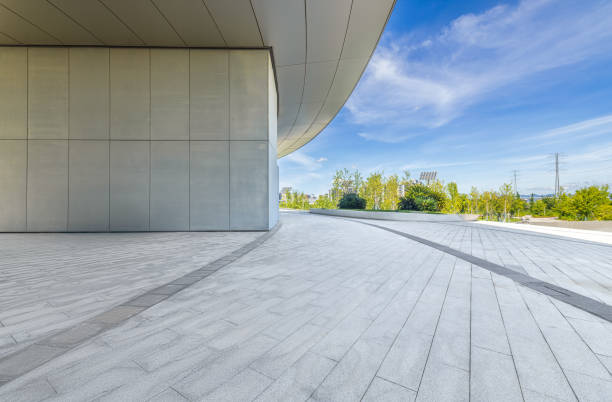 istock Empty pavement near modern building with blue sky and greenery 2205370679