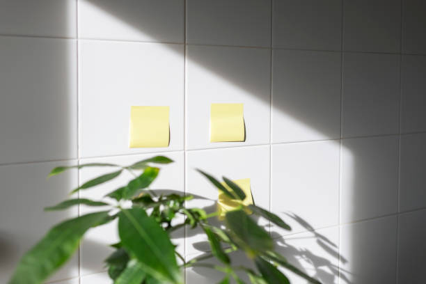 Yellow paper for notes is glued to the tiled wall
