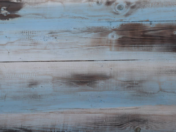 Distressed blue and brown wooden planks with visible grain and faded paint, offering a rustic textured background perfect for vintage themes, crafts, design layouts, and home decor