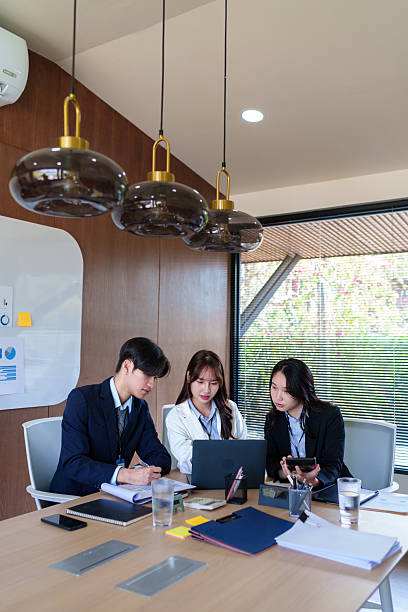istock Young startup professionals discussing business data on a laptop, analyzing financial growth and marketing strategies in a modern collaborative workspace for innovative decision-making 2205379142