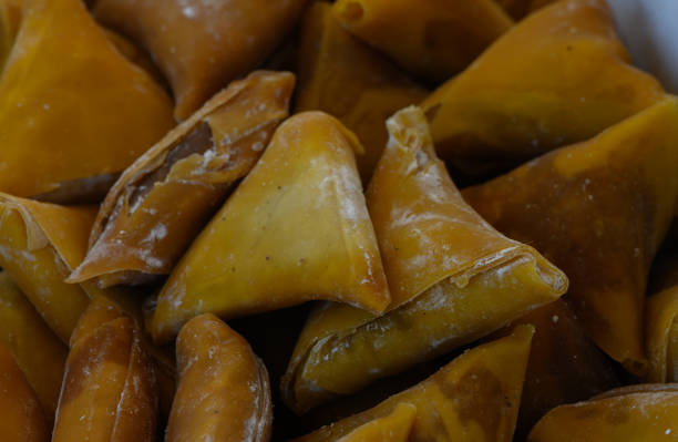 Delicious golden samosas ready to be served at an outdoor gathering in a vibrant market