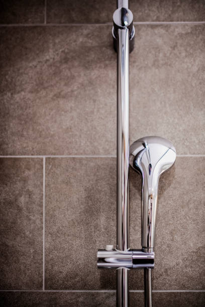 istock Modern Chrome Shower Head and Faucet on Tiled Bathroom Wall 2205380897
