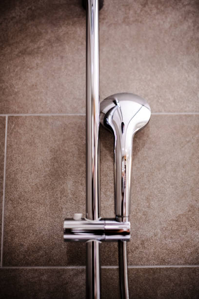 istock Modern Chrome Shower Head and Faucet on Tiled Bathroom Wall 2205380946