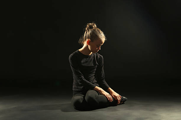 Young girl gymnast on black background
