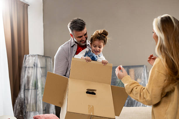 istock Girl playing in the box with mom and dad while moving in 2205388739