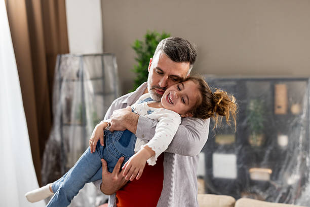 istock Man playing with his cute, little daughter while moving in 2205388740