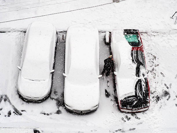 istock above view of driver removing snow from car 2205390949