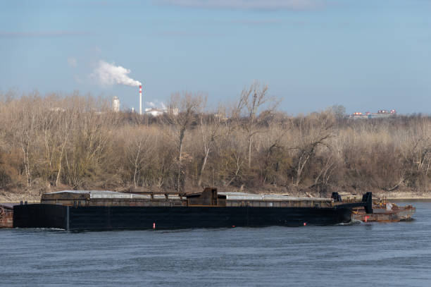 Aerial view of a barge passing a dam on a navigable river.