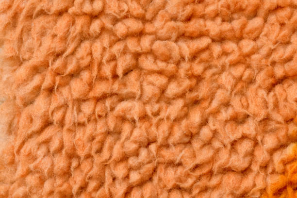 A striking orange background created from a macro photo of colored fleece. The image features a vibrant hue and a soft, three-dimensional texture, perfect for energetic, warm, or creative design concepts.