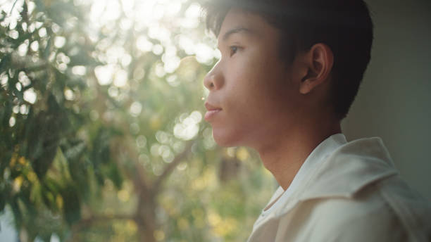 istock Teenager looking through the window. 2205392700