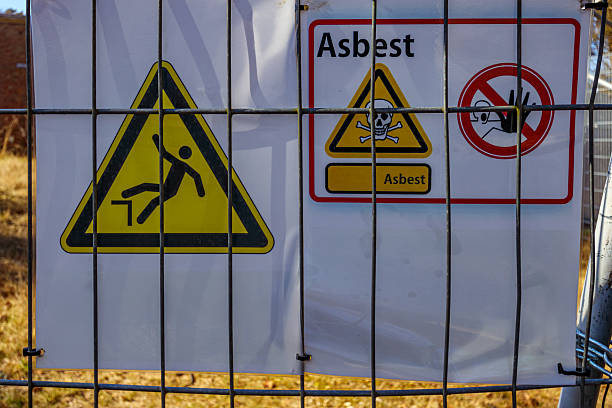 Asbestos hazard warning signs, tripping hazard, and no entry, damaged buildings, industrial development area, Herkenbosch, Limburg, Netherlands