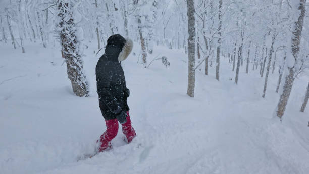istock Unrecognizable female snowboarder makes her way down a secluded forest trail. 2205394290