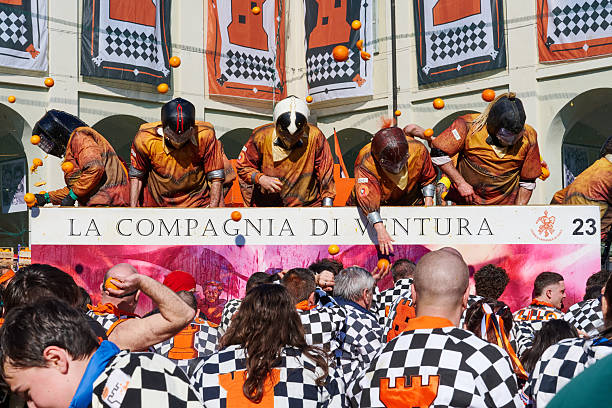 Ivrea, Italy - March 02, 2025: groups in traditional dressing take part in the Battle of the Oranges, where the \