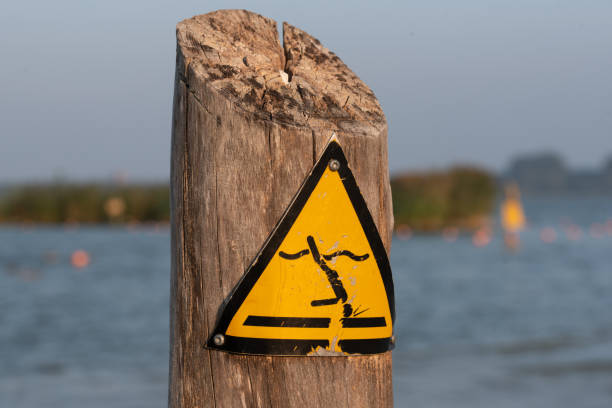 istock Safety warning sign – no diving, yellow triangle with falling figure 2205397556
