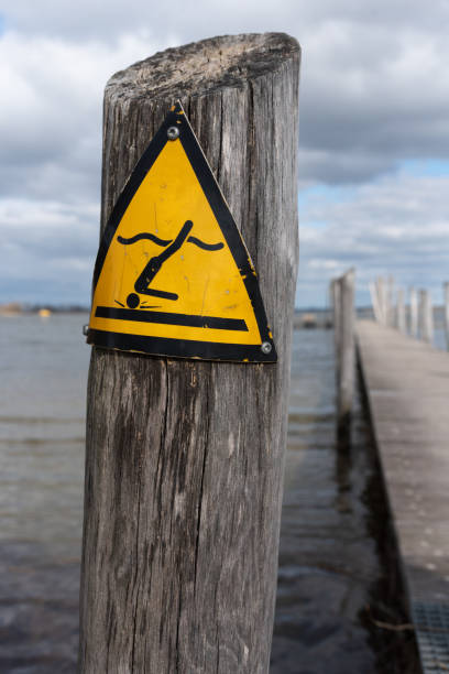 istock Safety warning sign – no diving, yellow triangle with falling figure 2205397696