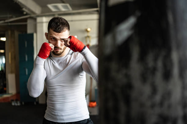 istock Focused Male Boxer Training with Hand Wraps in Gym Setting 2205397953