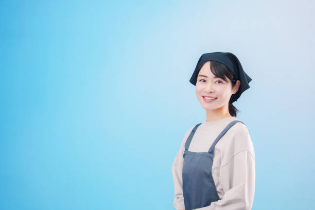 istock Young woman cook wearing apron (light blue background) 2205398445
