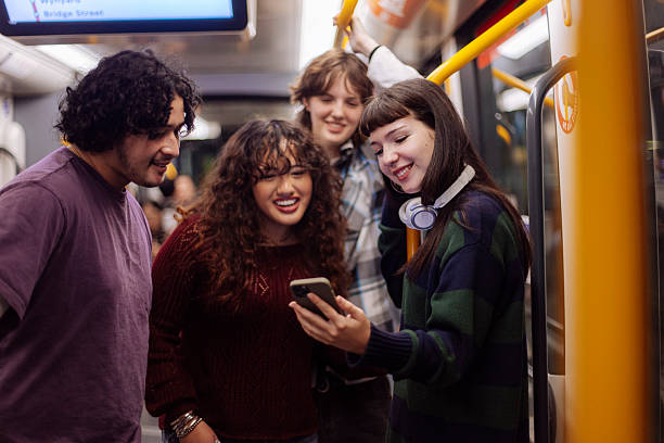istock Teeange friend smiling at phone in subway ride 2205398554