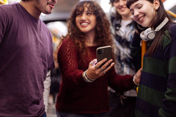 istock Teeangers at subway train smiling at phone 2205399684
