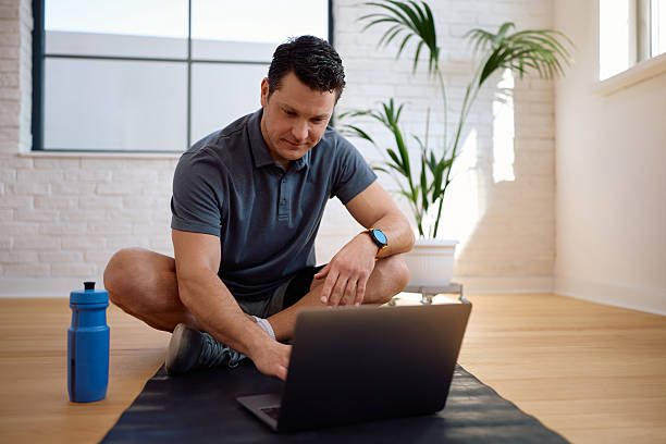 istock Smiling coach using laptop while relaxing at his fitness studio. 2205400584