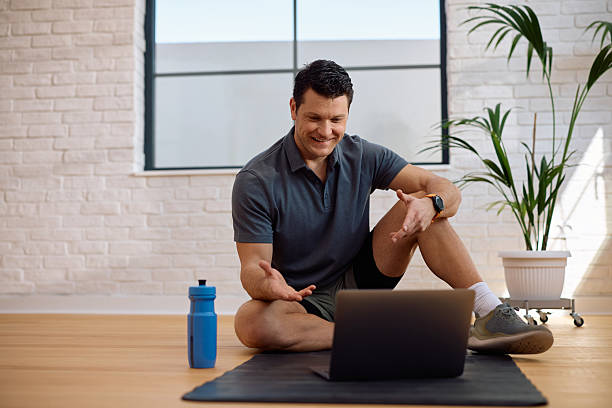 istock Happy fitness instructor using laptop during online exercise class. 2205400599