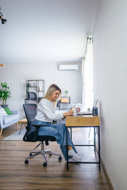 istock Young female student studying at home on her laptop 2205401282